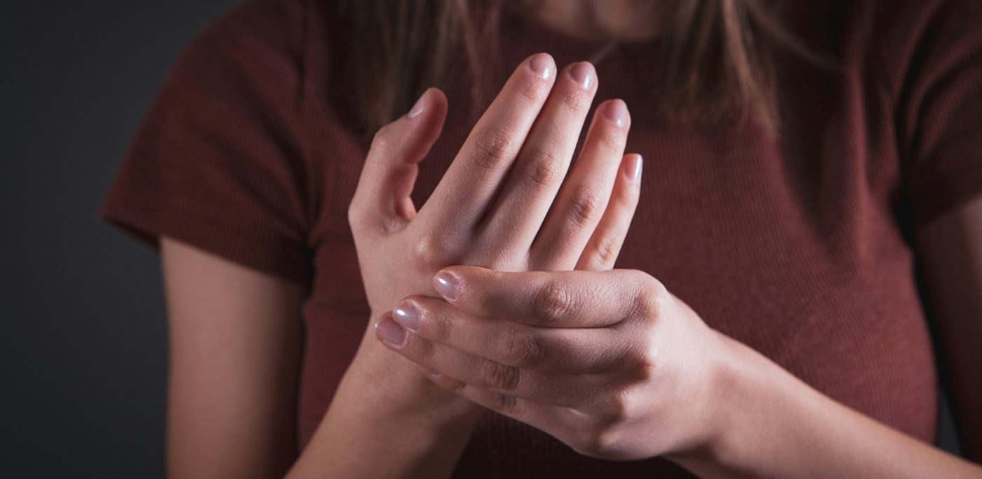 Hands holding a sore wrist